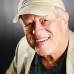 Robert Spiller's testimonial photo for The Novel View. A cheerful older man wearing a hat and jacket showcasing a friendly smile and a welcoming presence.