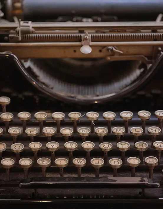 An old typewriter with visible keys, showcasing its vintage design and charm, perfect for editing and writing enthusiasts. The Novel View's Frequently Asked Questions Page image.
